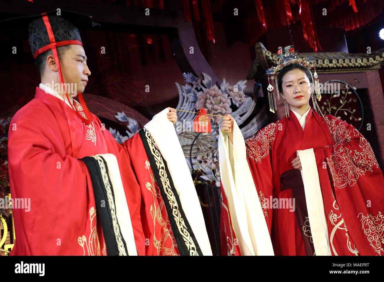 Anhui, Anhui, China. 20th Aug, 2019. Anhui, CHINA-A ''splendid'' Chinese wedding ceremony is successfully held in the grand banquet hall of Huayi hotel in Wuhu, Anhui province, Aug. 17, 2019.The theme of the Chinese wedding show highlights the Chinese wedding customs, attracting more than 100 couples and many wedding brands invited to participate in the scene, beautiful models wearing beautiful bridal suits on the runway very beautiful eyes. Credit: SIPA Asia/ZUMA Wire/Alamy Live News Stock Photo