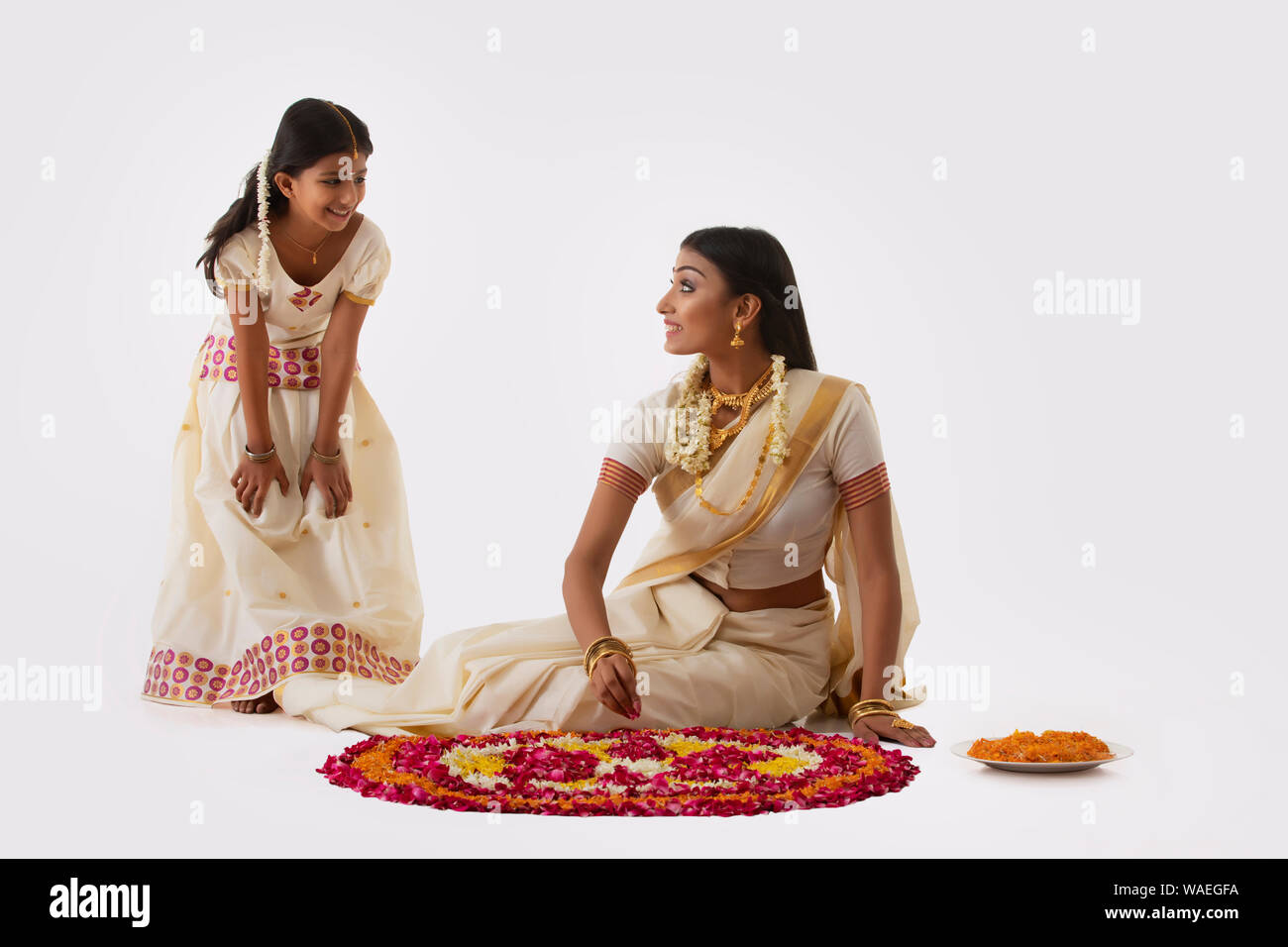 mother and daughter talking while making rangoli on onam Stock Photo ...