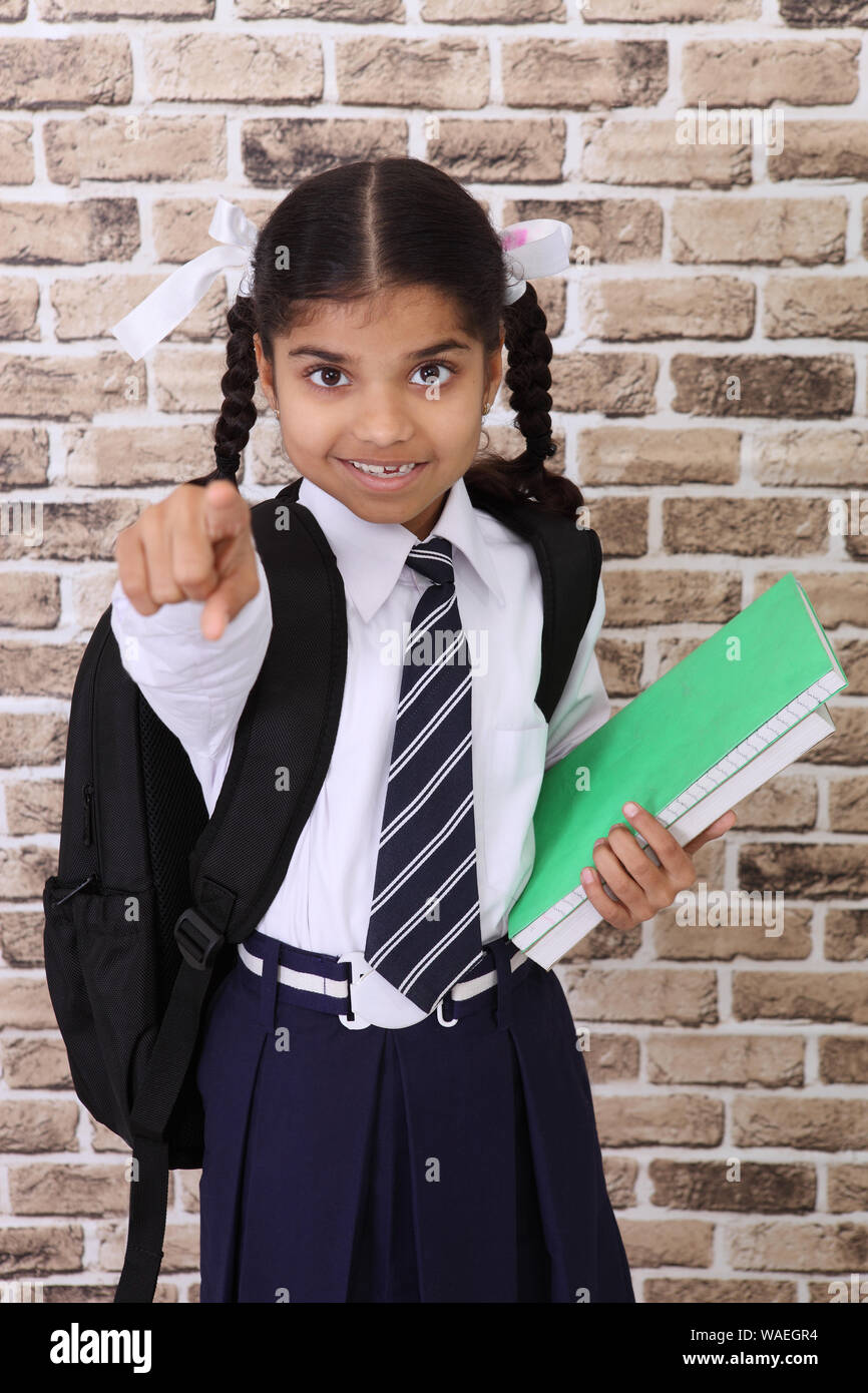 Girl carrying books on her head and smiling Stock Photo - Alamy