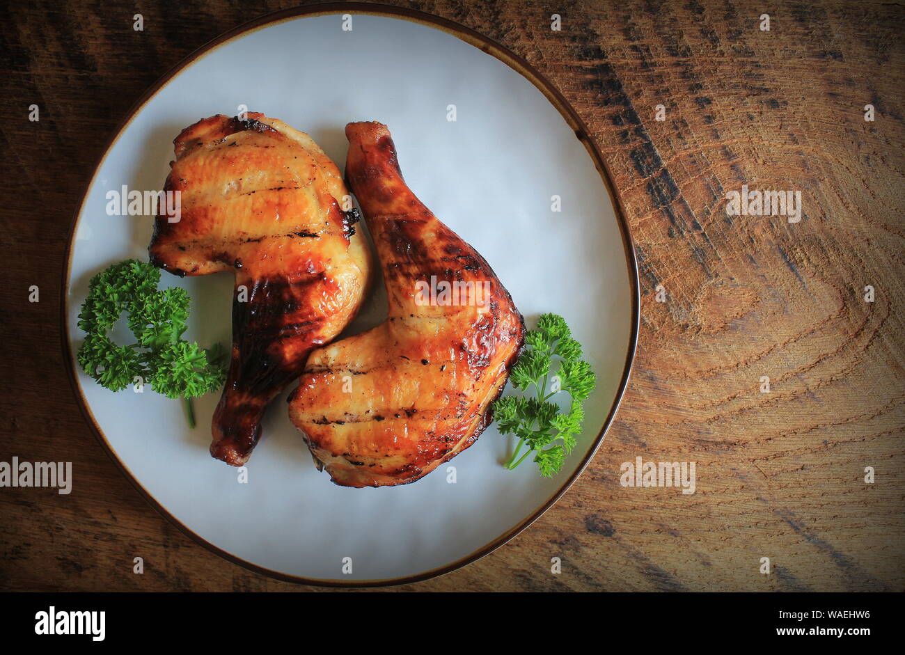 Grilled Chicken Leg Quarters With Crispy Golden Brown Skin Parsley On White Plate On Dark Wooden Boards Food Background Top View Stock Photo Alamy