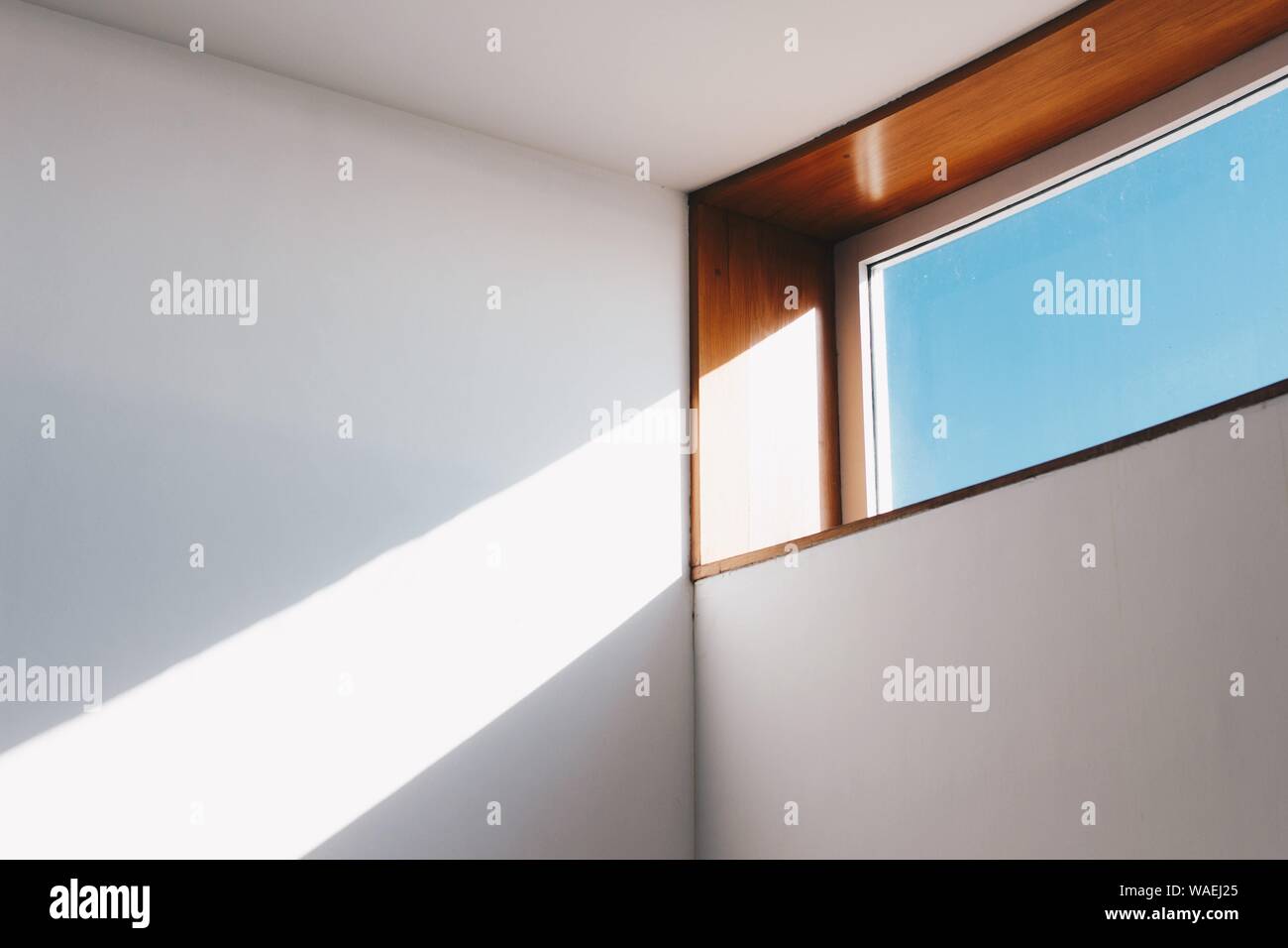 Sunlight shining in through a rectangle window onto white walls Stock Photo
