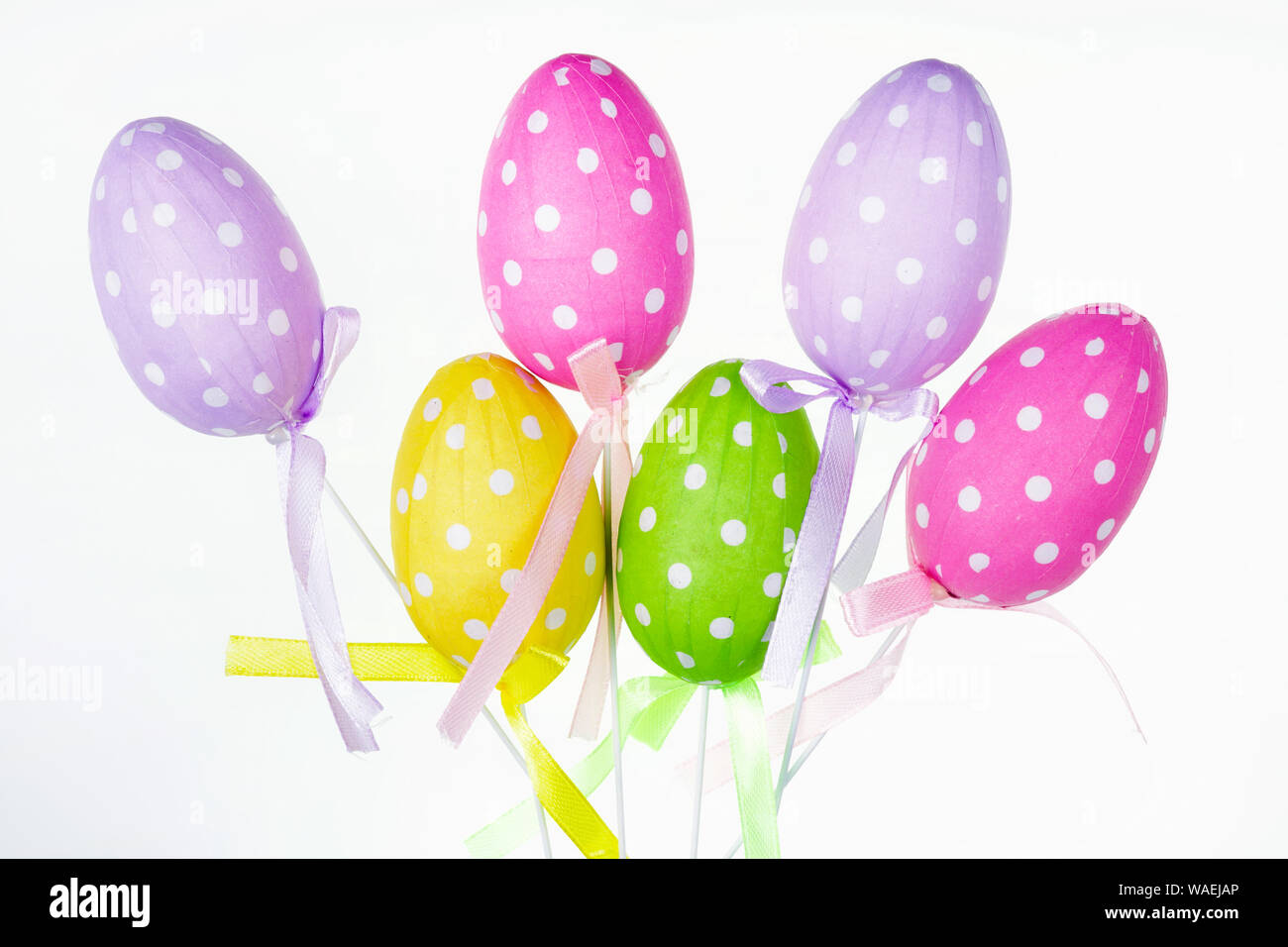 Traditional rustic style homemade paper Easters eggs on sticks on white bacjground Stock Photo