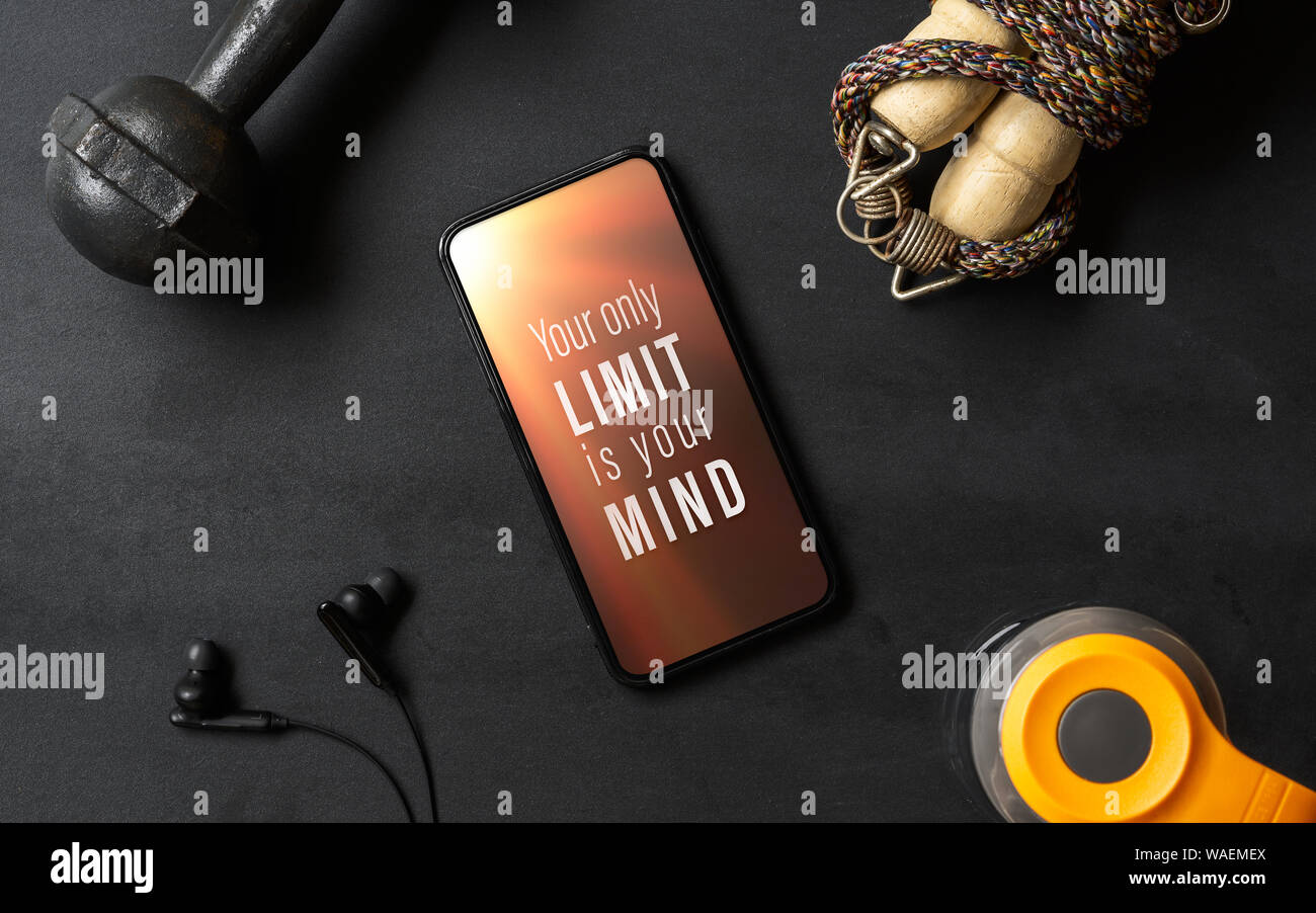 Your only limit is your mind. Inspirational motivational quotes fitness healthy goals with mockup mobile phone on grunge black table with dumbbells, J Stock Photo
