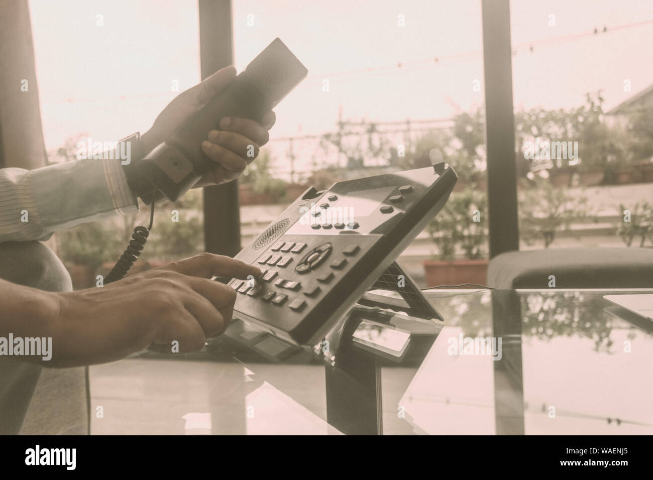 Close up male of hand holding telephone receiver and dialing a
