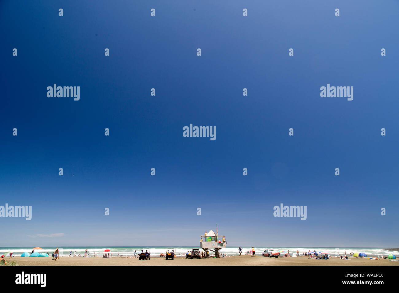 Scorching hot day at Bethells Beach, west Auckland. Black sand gets hot