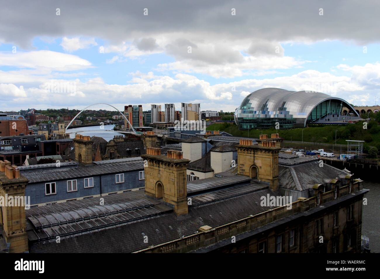 The Sage concert venue int the distance overlooking building roof tops, and cloudy  blue sky, in Gateshead, New castle upon tyne Stock Photo
