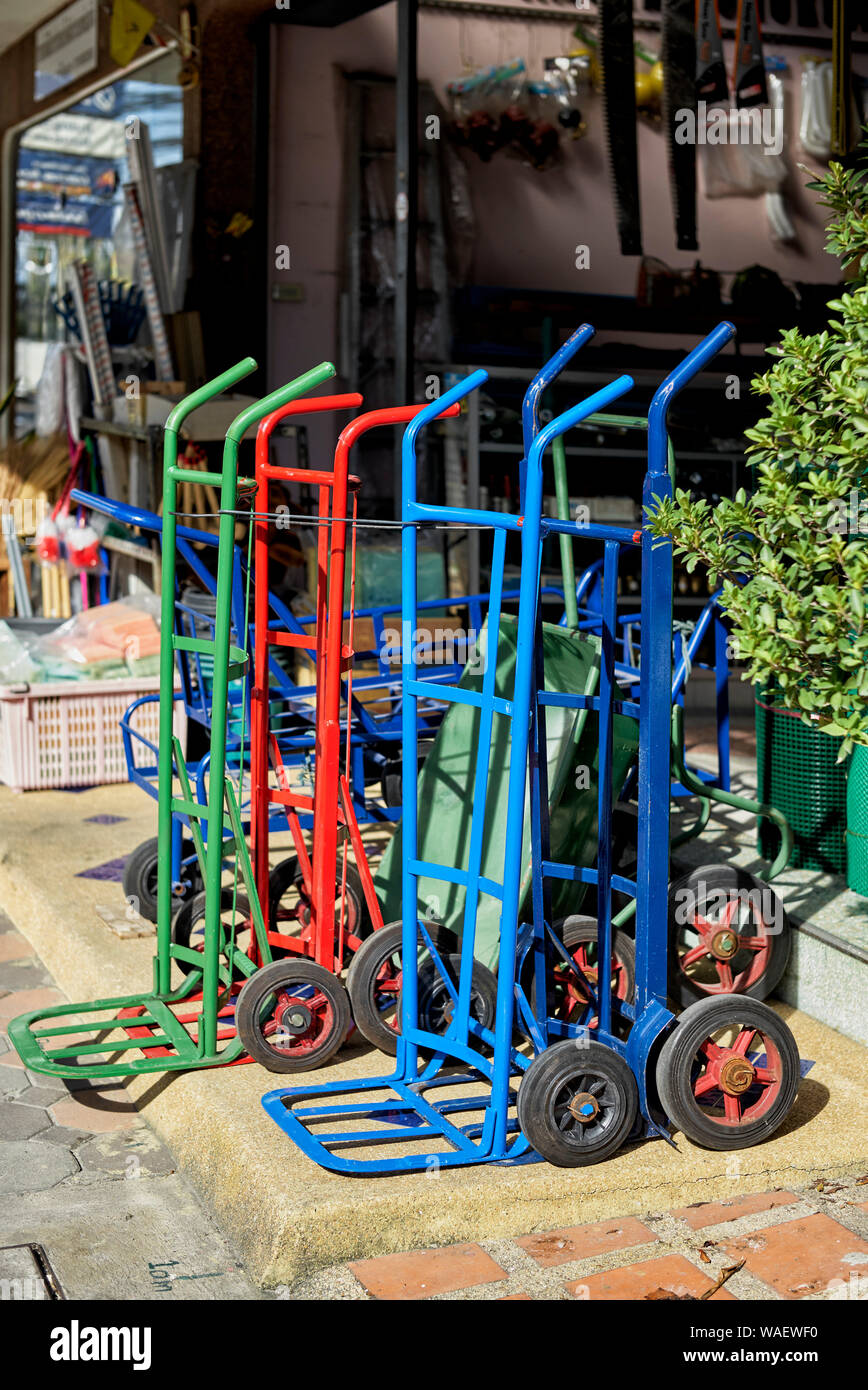 Hand trolley of various colours for sale at a Hardware store Thailand Southeast asia Stock Photo