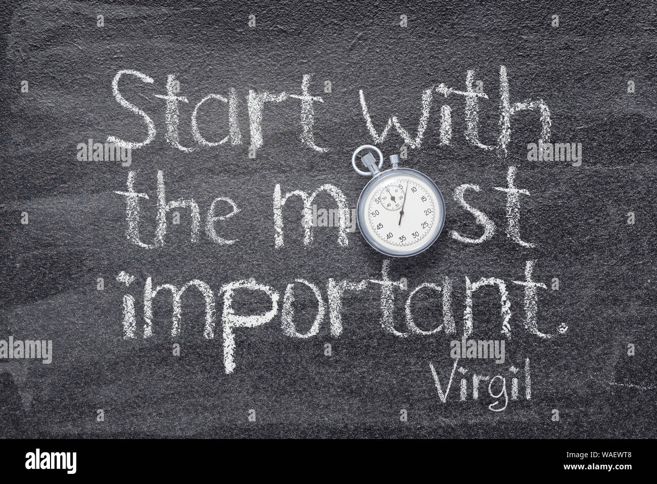 Start with the most important - quote of ancient Roman poet Virgil written on chalkboard with vintage precise stopwatch Stock Photo