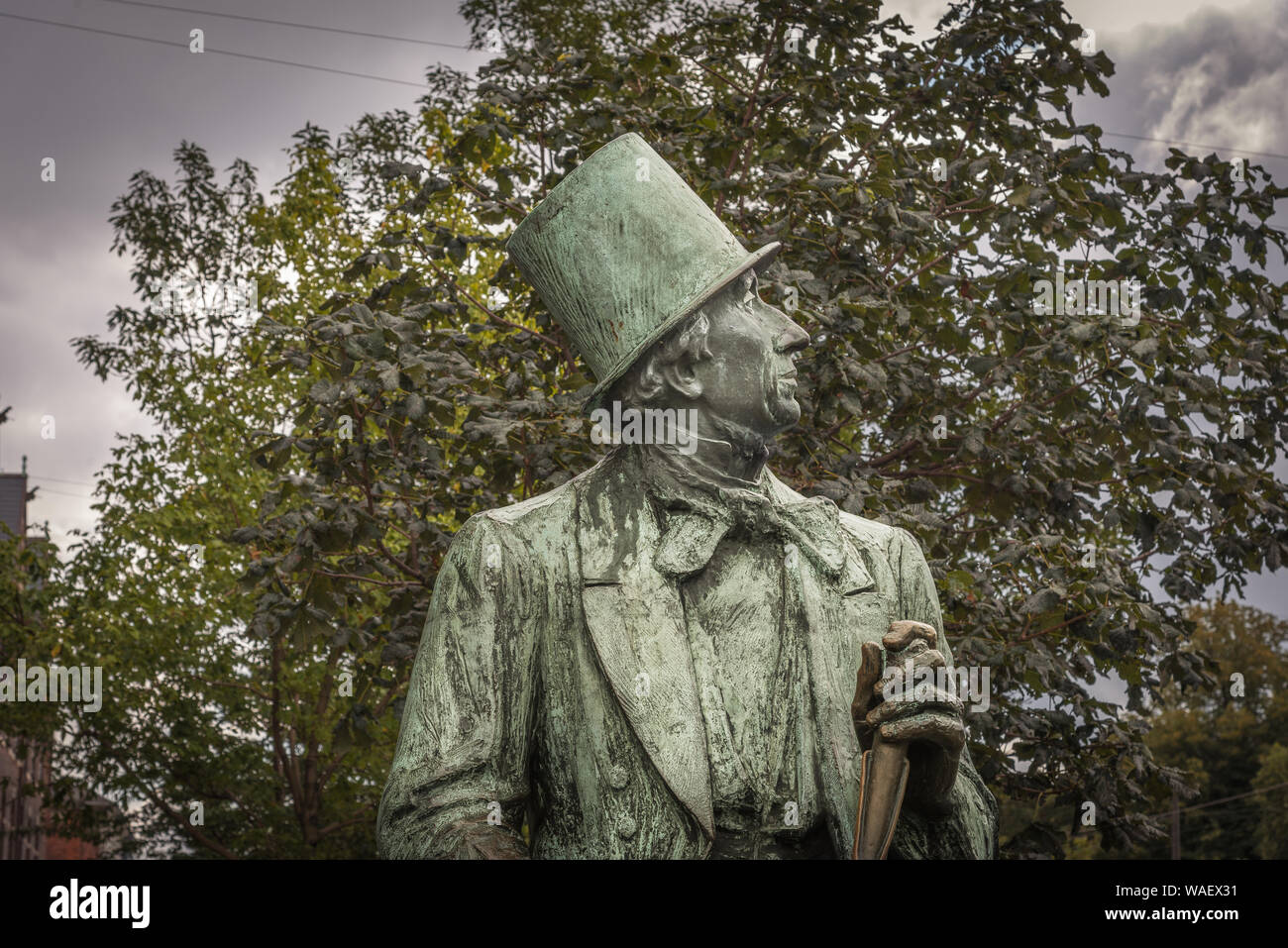 Statue of H C Andersen sitting in a top hat in front of a tree, Copenhagen,  Denmark, August 16, 2019 Stock Photo - Alamy