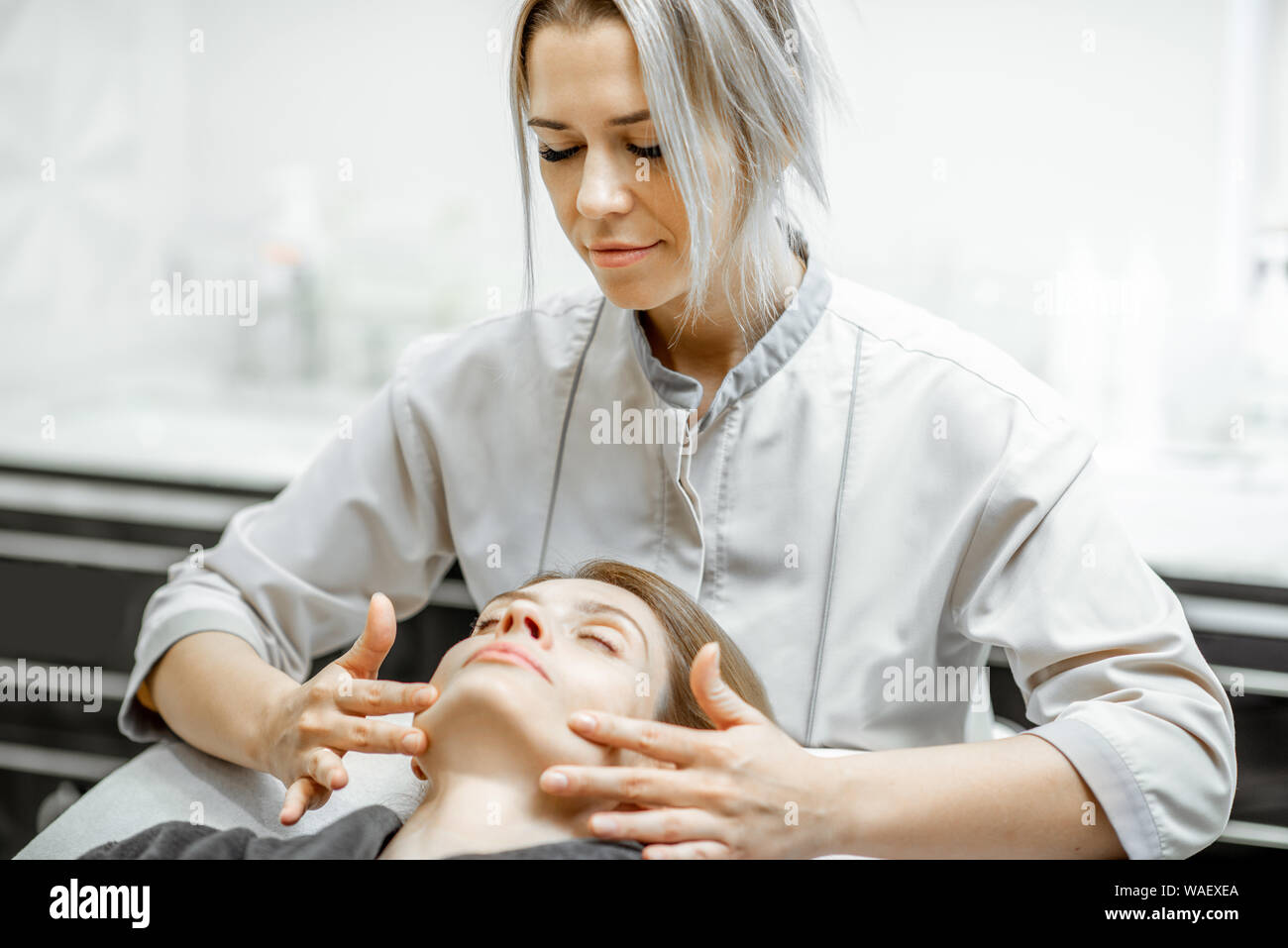 Cosmetologist Making Facial Massage To A Beautiful Woman At The Beauty Salon Concept Of A Lymph