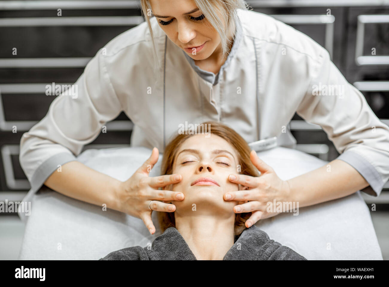 Cosmetologist Making Facial Massage To A Beautiful Woman At The Beauty Salon Concept Of A Lymph