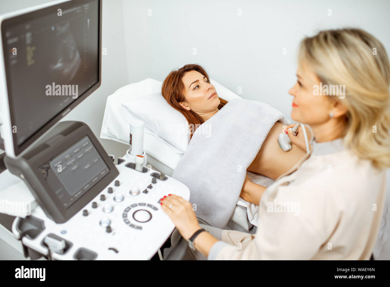 Female doctor performs ultrasound examination of a women's pelvic