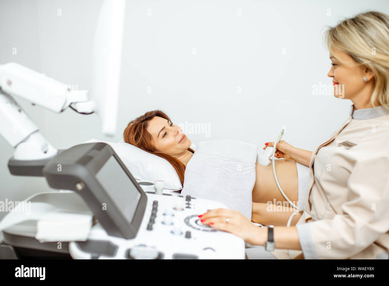 Female doctor performs ultrasound examination of a women's pelvic