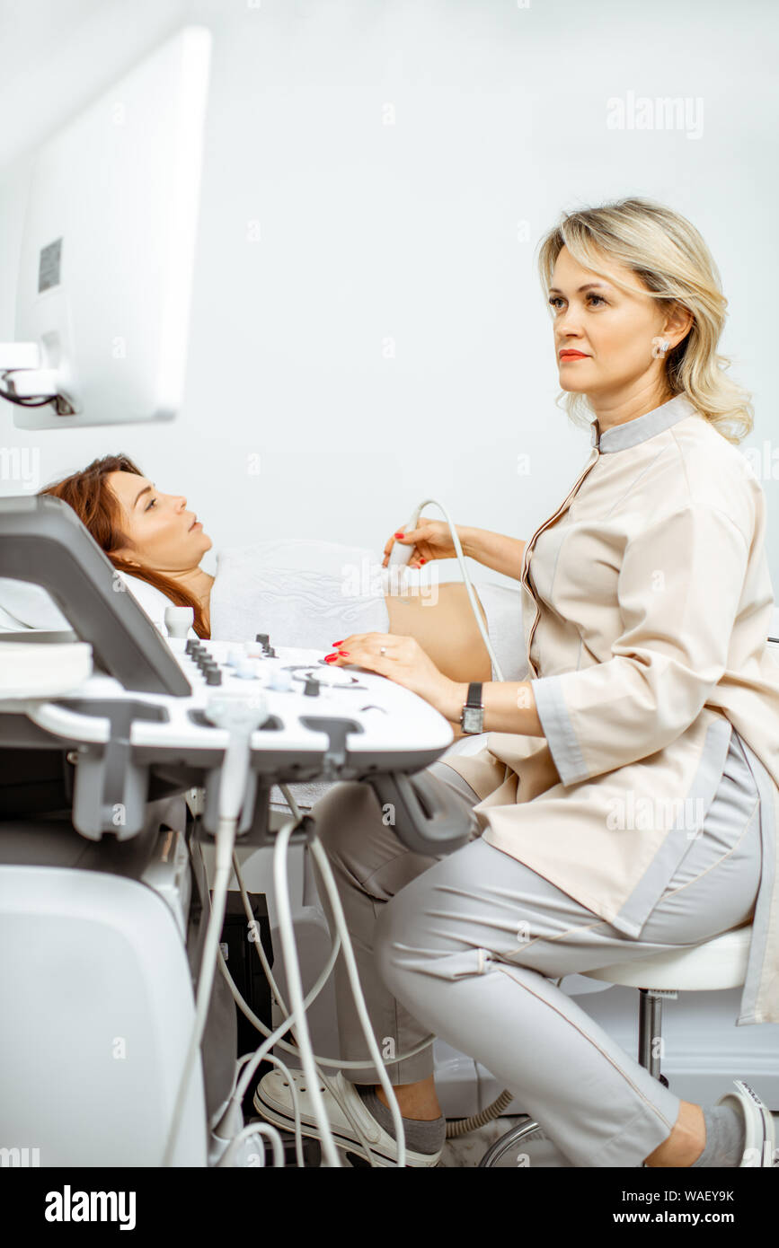 Female doctor performs ultrasound examination of a women's pelvic