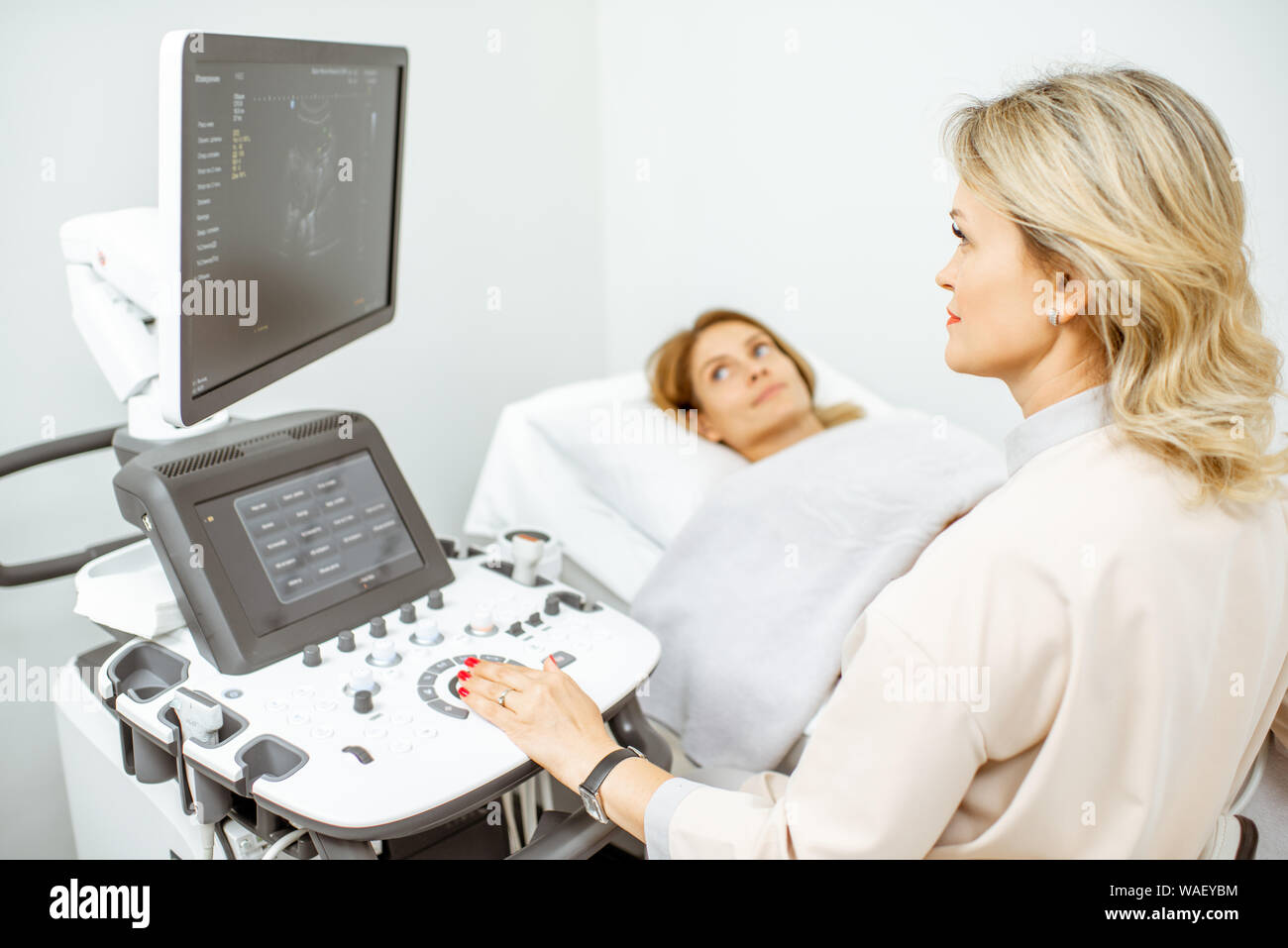 Female doctor performs ultrasound examination of a women's pelvic