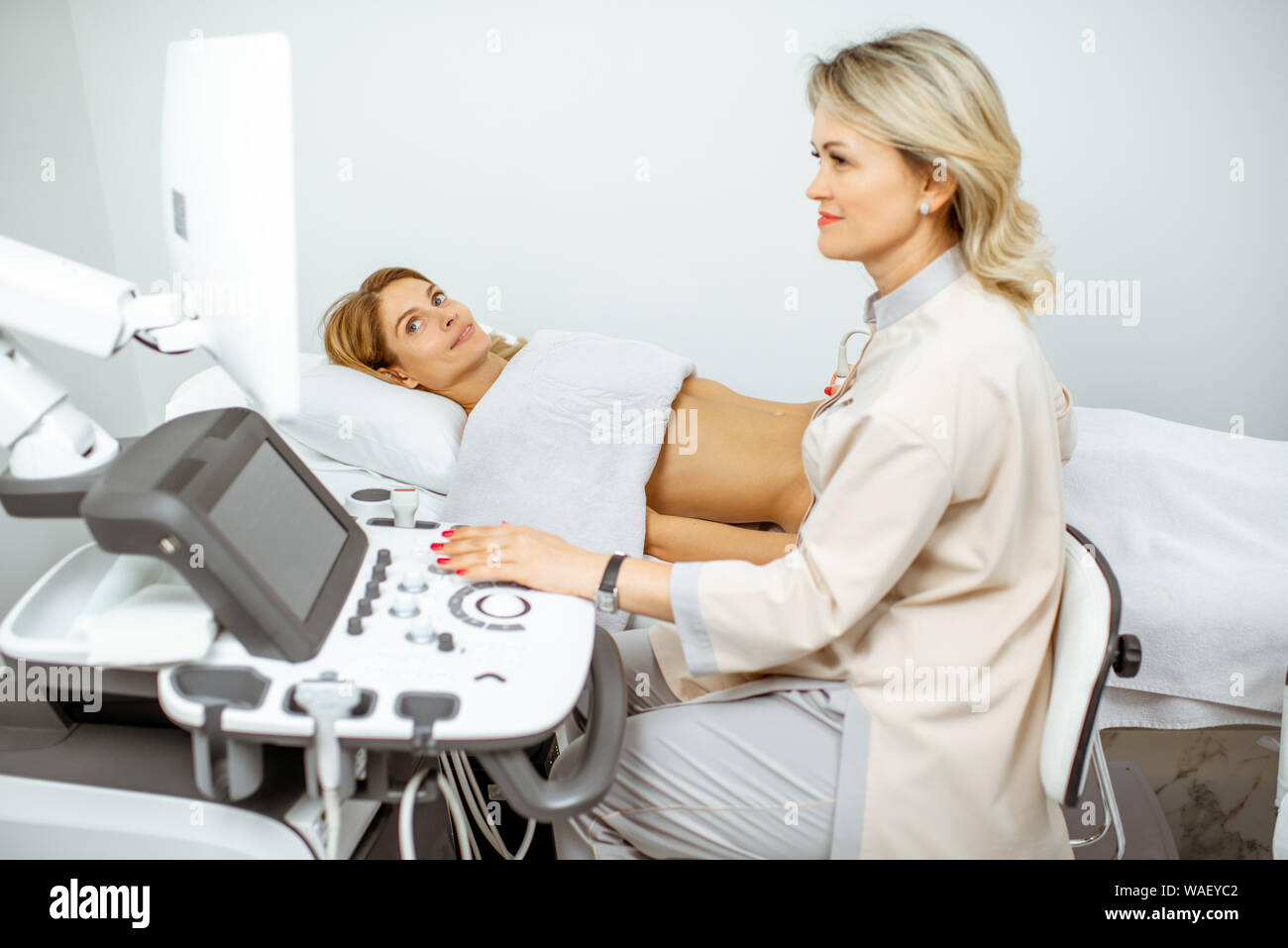 Female doctor performs ultrasound examination of a women's pelvic