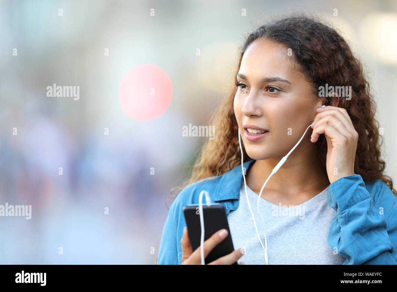 Girl putting in earbuds hi res stock photography and images Alamy