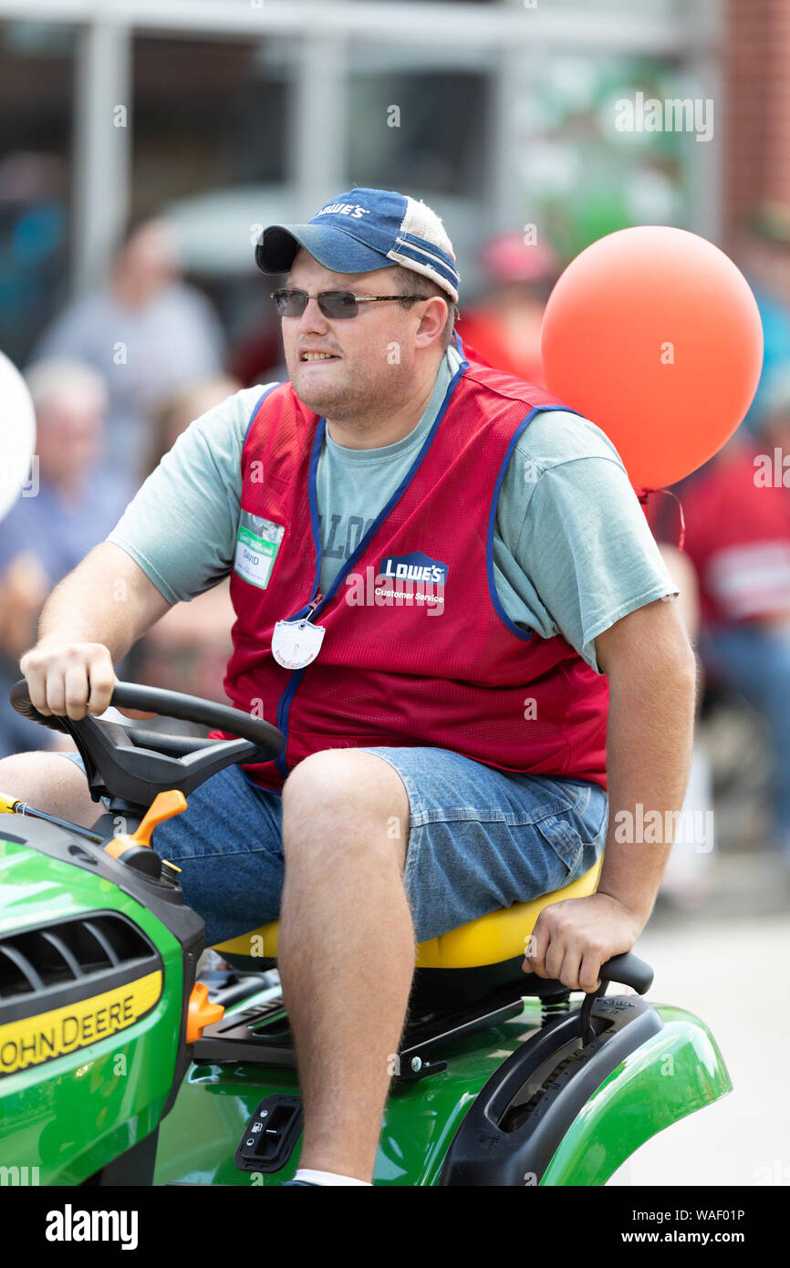 Buckhannon, West Virginia, USA - May 18, 2019: Strawberry Festival, Lowe's employee riding a John Deere Lawn mower, promoting Lowe's during the parade Stock Photo