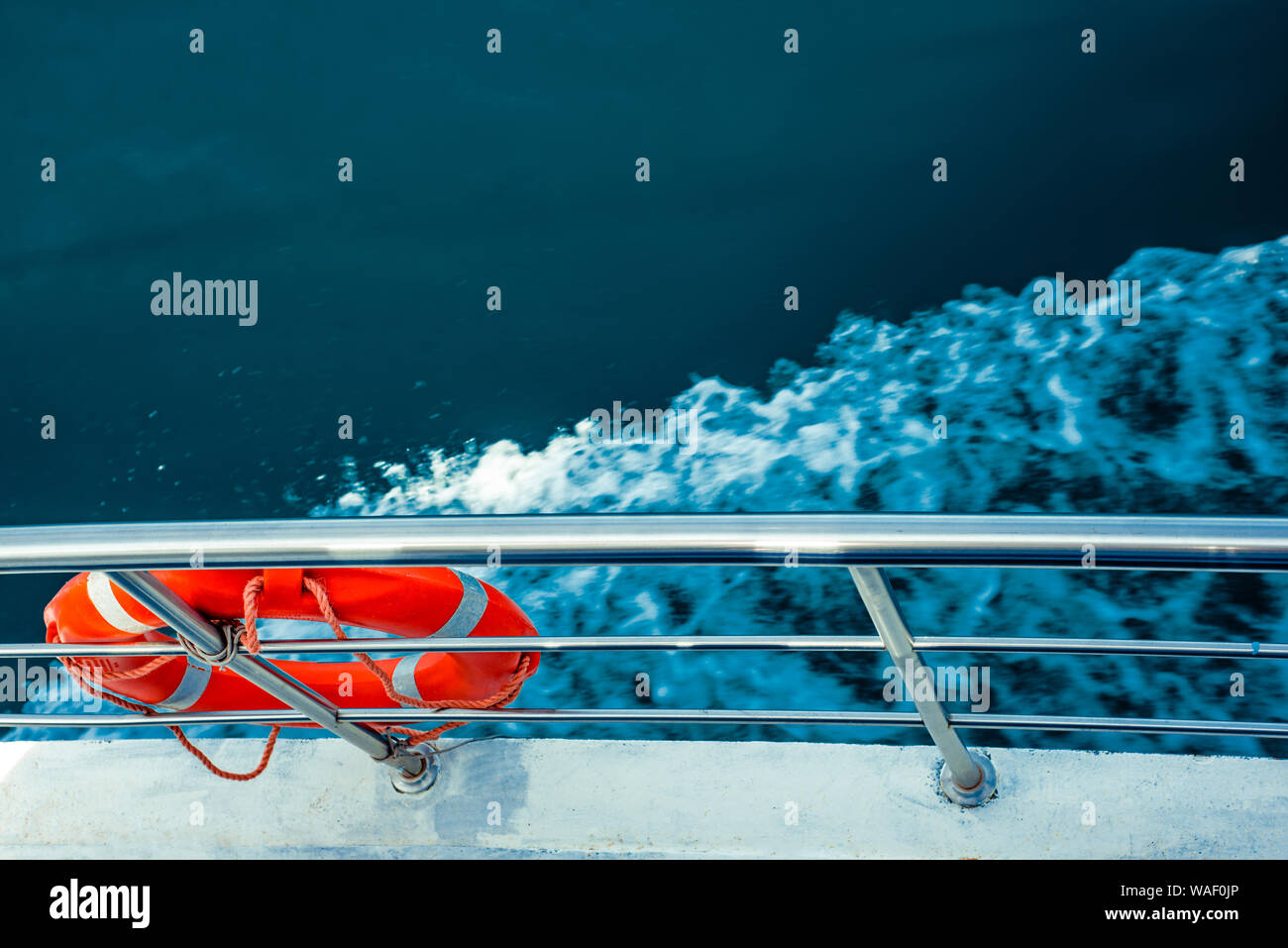 Red lifebuoy on ship railing with sea surface Stock Photo - Alamy