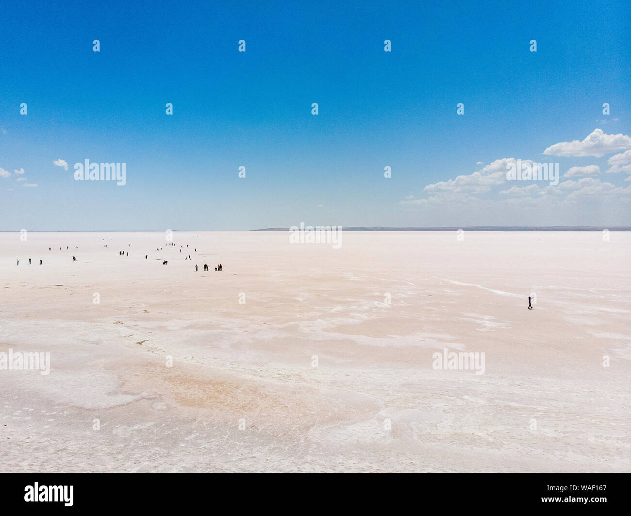 Aerial view of Lake Tuz, Tuz Golu. Salt Lake. White salt water. It is the second largest lake in Turkey. People standing in the middle of the lake Stock Photo