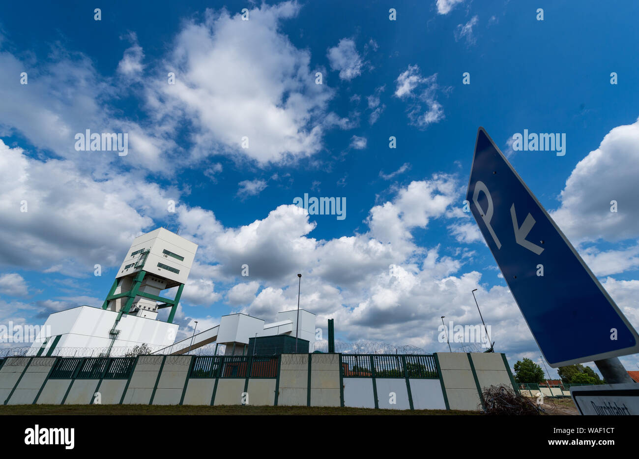 Gorleben, Germany. 08th Aug, 2019. Parts of a wall surrounding the former Gorleben exploratory mine can be seen in front of the winding tower. In the coming period, the wall that enclosed the site will be demolished. Credit: Philipp Schulze/dpa/Alamy Live News Stock Photo