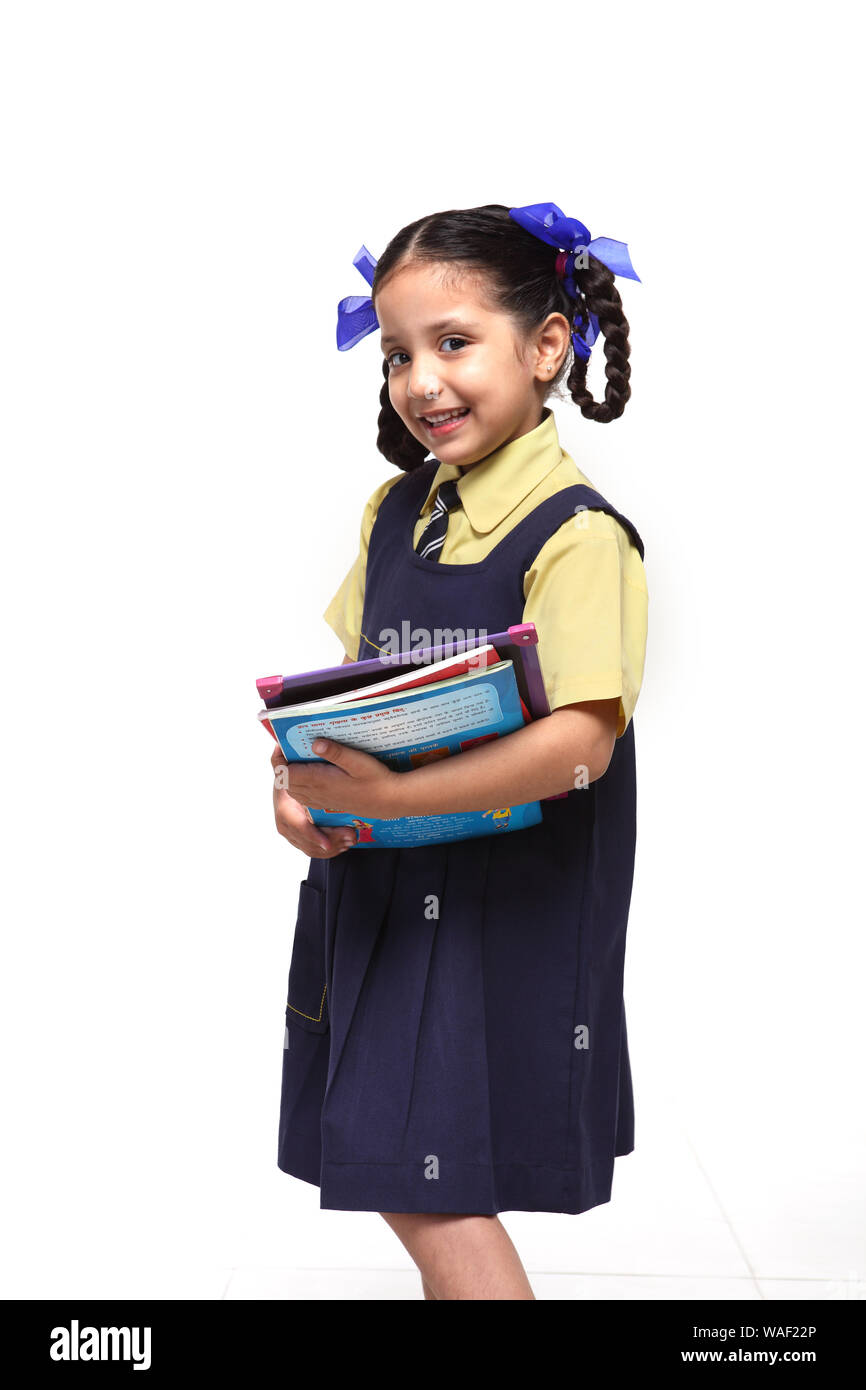 Schoolgirl standing and holding books Stock Photo - Alamy