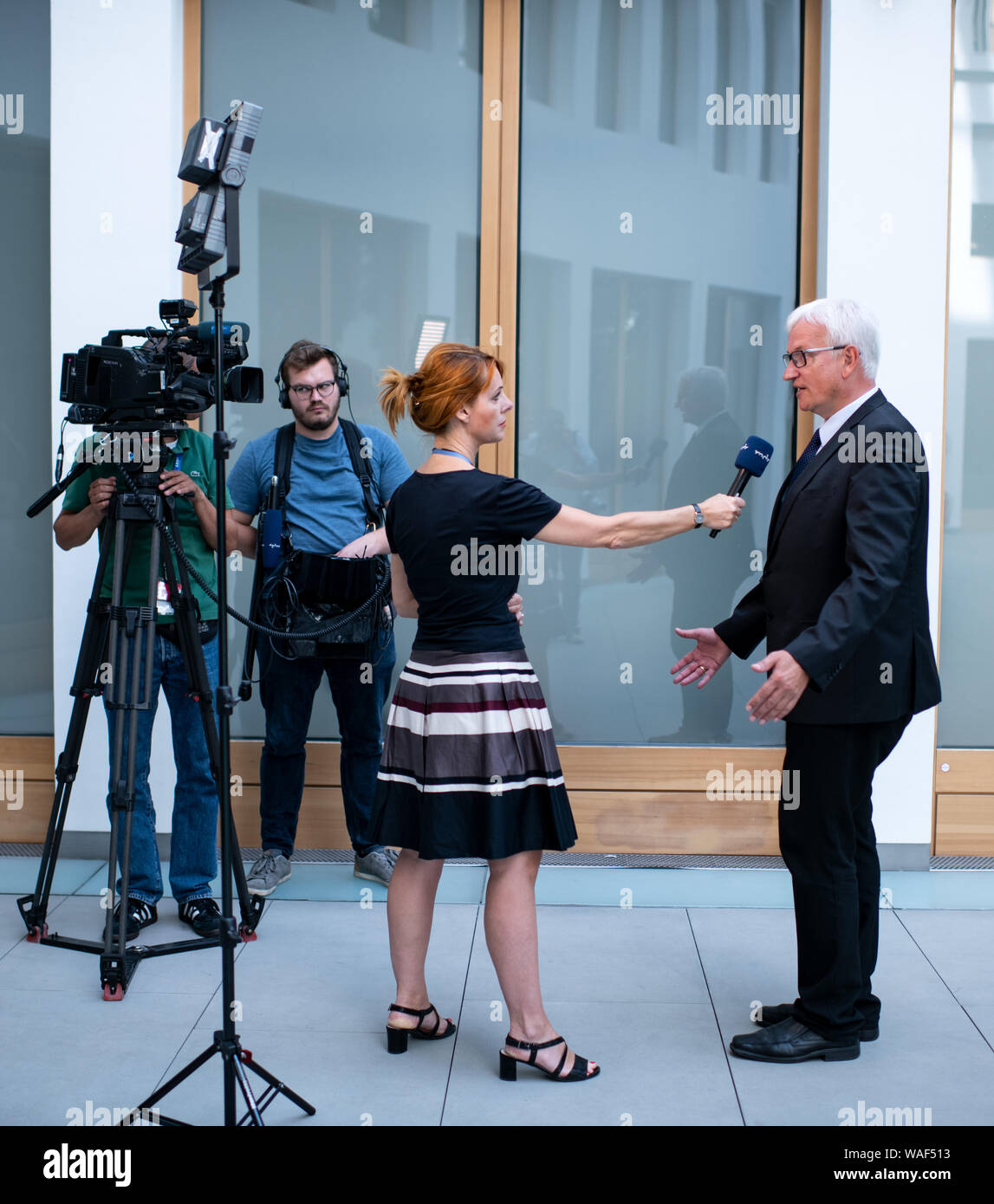 Berlin, Germany. 20th Aug, 2019. Jürgen Resch, Managing Director of Deutsche Umwelthilfe (DUH), is interviewed by a television team on the occasion of a press conference of Deutsche Umwelthilfe on the future of the automotive industry in Germany at the Haus der Bundespressekonferenz. Credit: Bernd von Jutrczenka/dpa/Alamy Live News Stock Photo