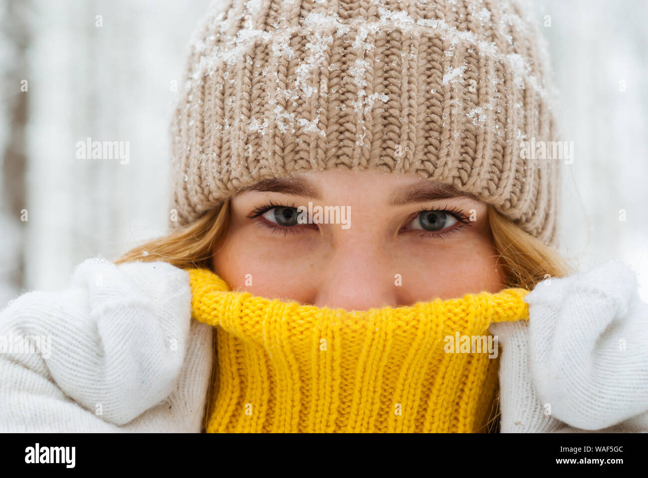 portrait of a girl warming up with her breath hiding her nose in the collar of a warm sweater close up Stock Photo Alamy