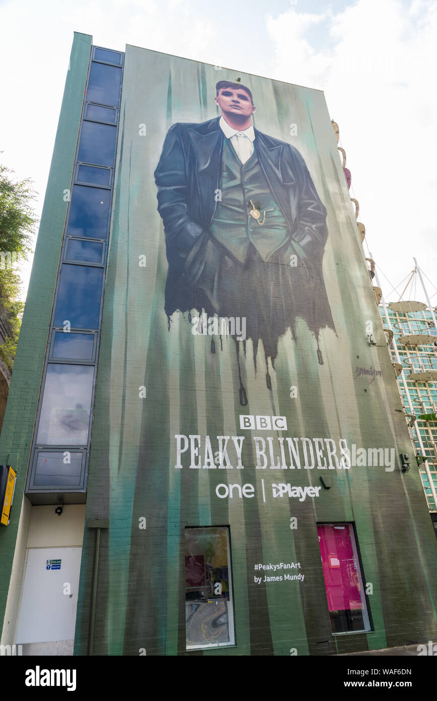 Mural depicting Tommy Shelby, played by Cillian Murphy, in the new series of Peaky Blinders painted on the wall of a building in the Custard Factory Stock Photo
