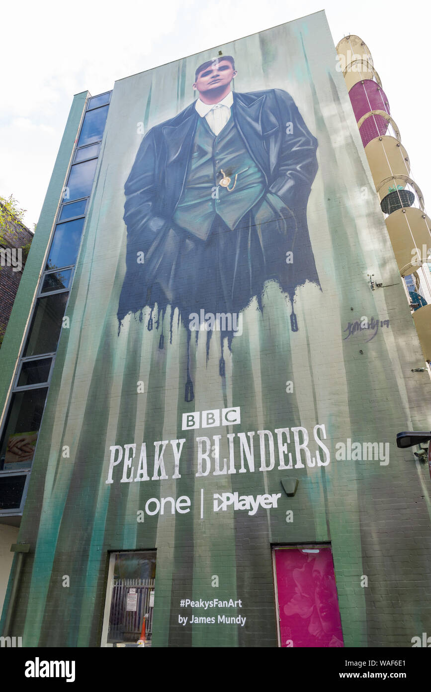 Mural depicting Tommy Shelby, played by Cillian Murphy, in the new series of Peaky Blinders painted on the wall of a building in the Custard Factory Stock Photo