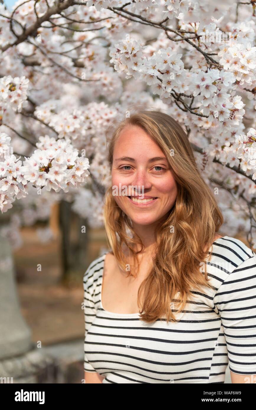 Tourist, young woman in front of blossoming cherry blossoms, Japanese