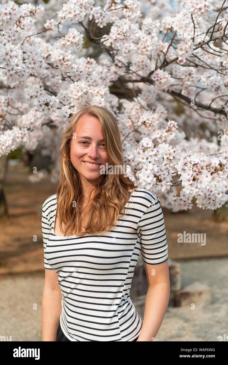 Tourist, young woman between blossoming cherry blossoms, Japanese cherry blossom in spring, Tokyo, Japan Stock Photo