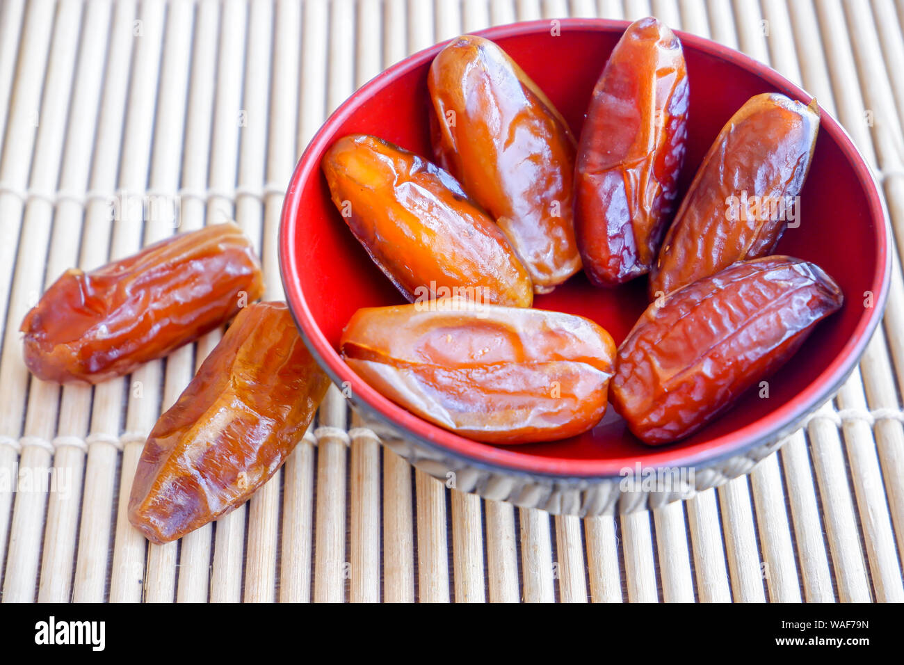 Group of Phoenix fruit in red bowl on bamboo mat. Stock Photo