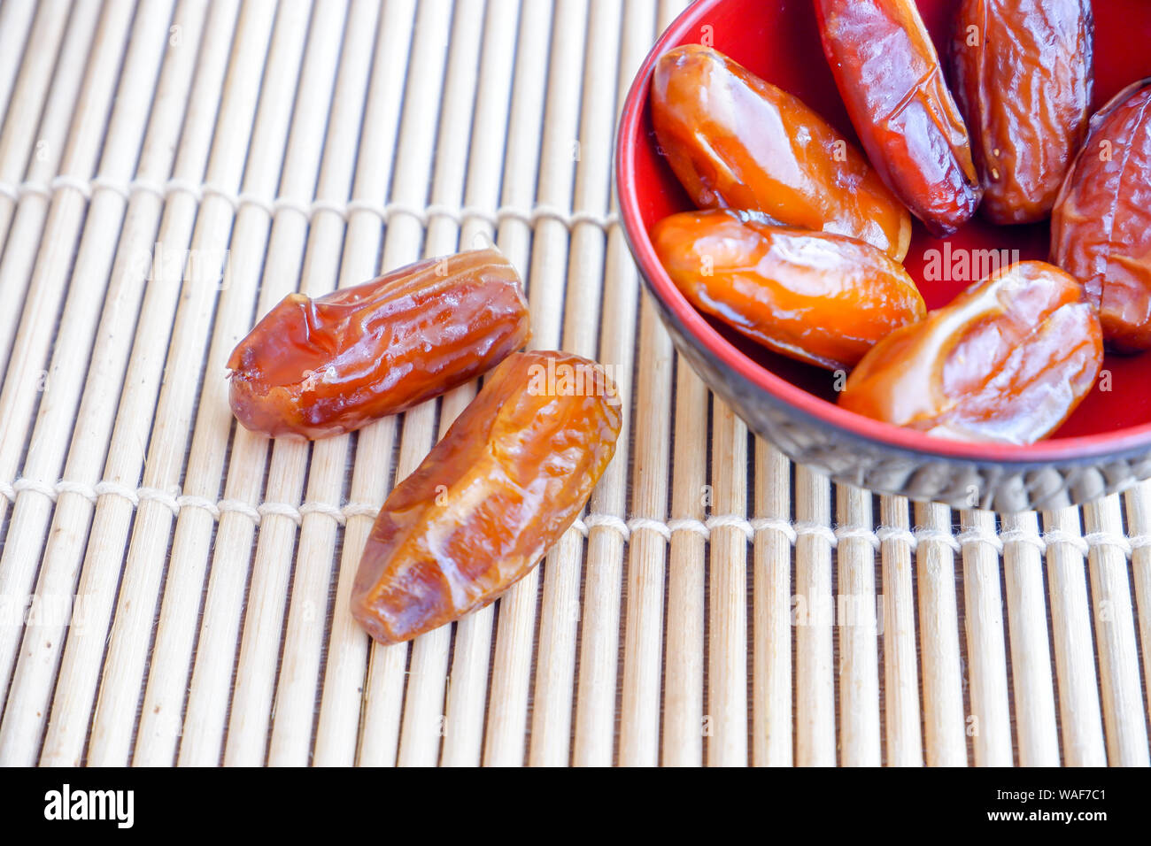 Group of Phoenix fruit in red bowl on bamboo mat. Stock Photo