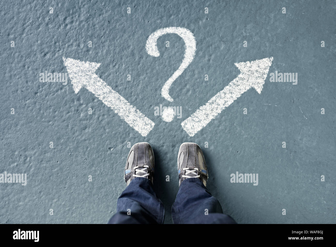 Taking decisions for the future man standing with direction arrow choices and question mark, left, right or move forward Stock Photo