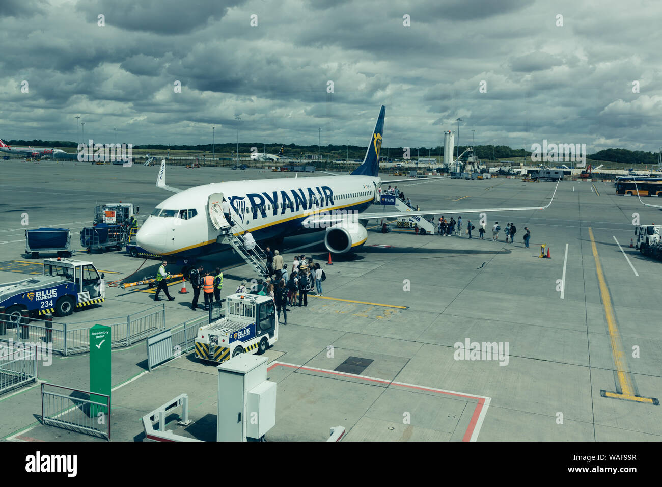 LONDON - AUGUST 7, 2019: People boarding RyanAir airplane at airport terminal at London Stansted Stock Photo