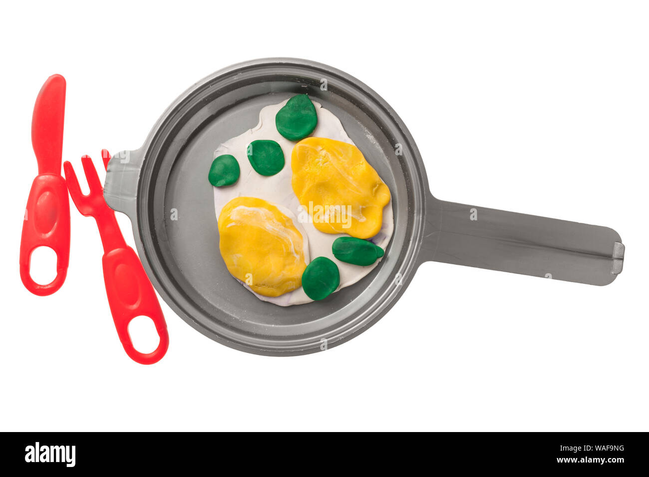 Toy from plasticine fried eggs in a pan Stock Photo