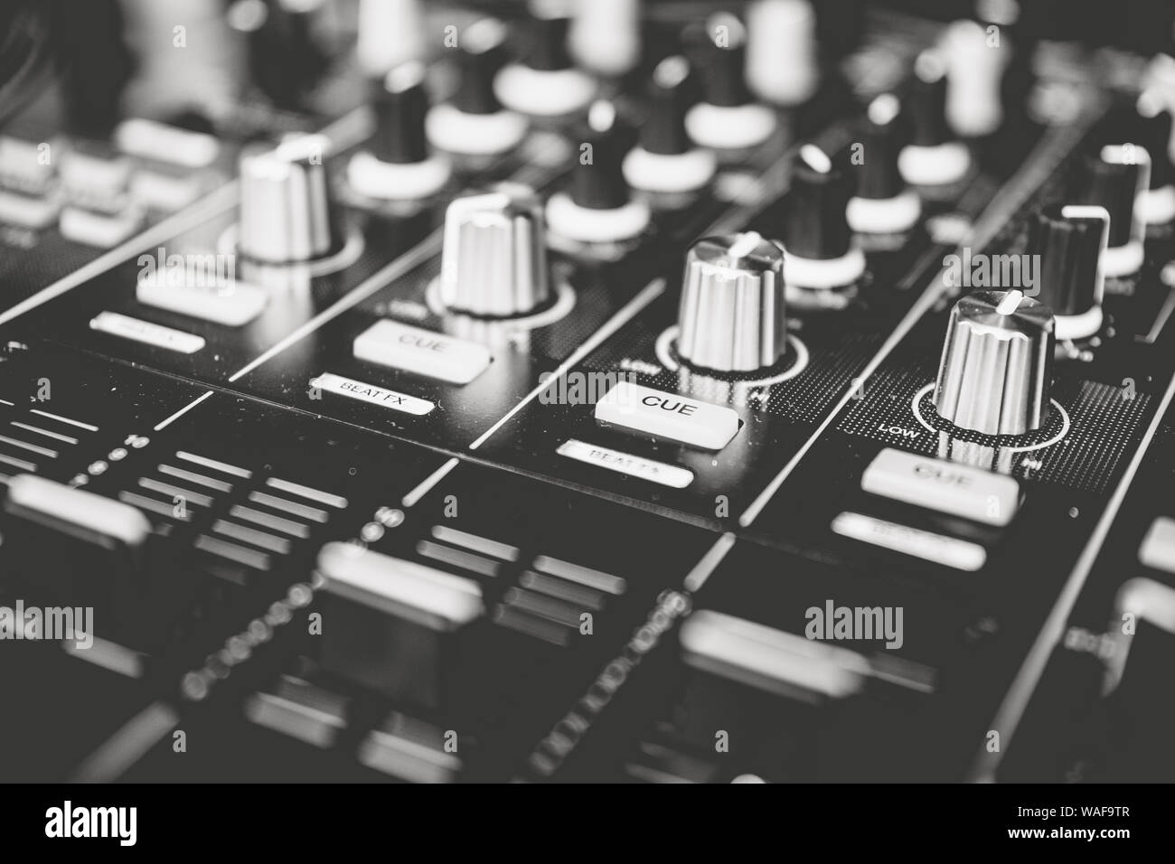 A close up of a DJ's sound mixer desk in black and white. Stock Photo