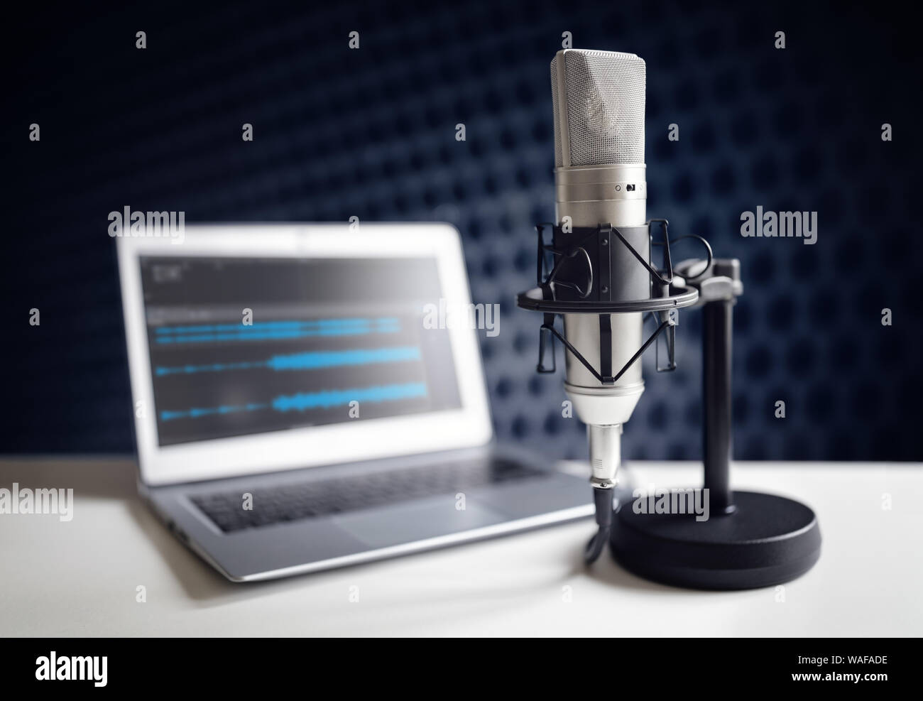 Podcast microphone and laptop computer on desk in recording studio Stock Photo