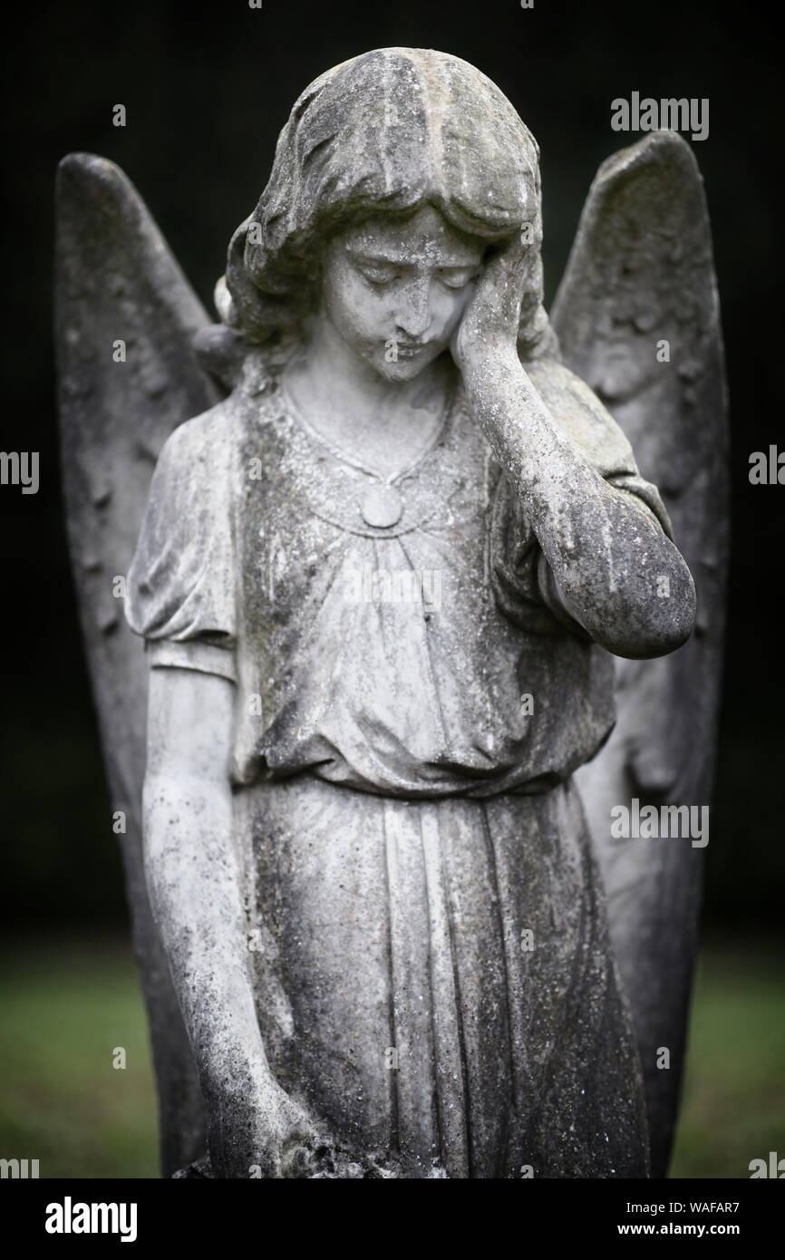 Guardian angel statue forlorn in graveyard Stock Photo