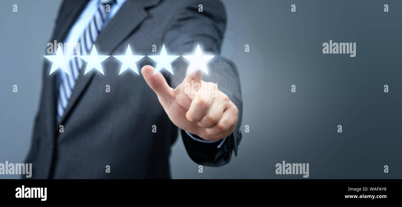 Businessman pointing to five star service rating symbol with copy space Stock Photo