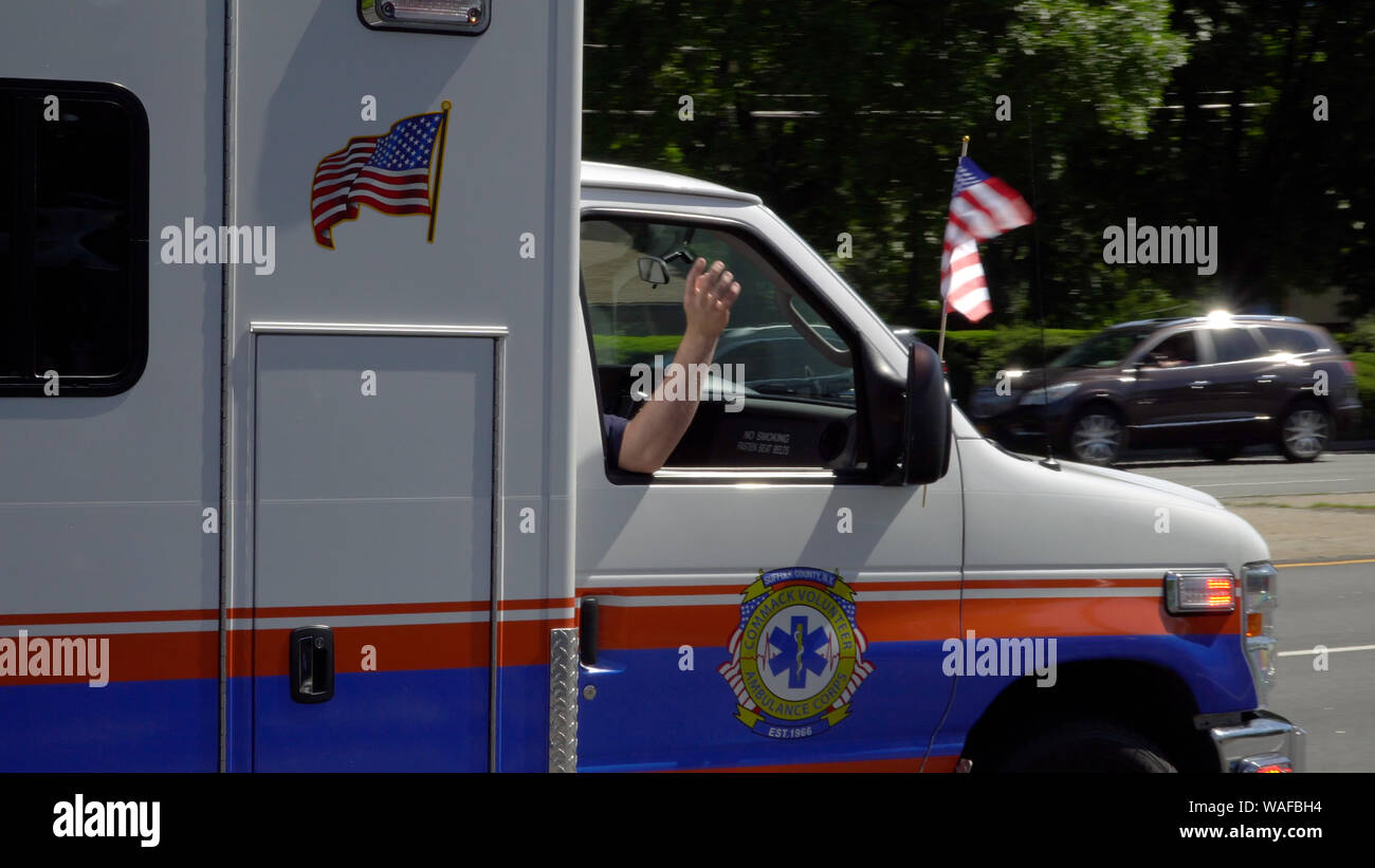 Long Island, NY - Circa 2019: Ambulance emergency vehicle close up driving in memorial day parade during bring summer day celebrate america freedom an Stock Photo
