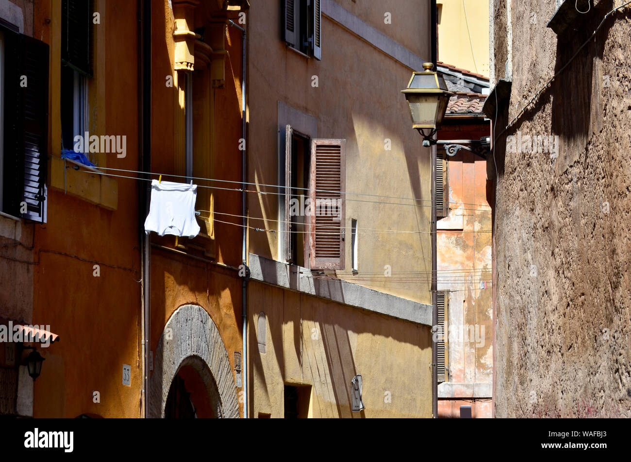 White t-shirt hung in the sun and Roman facades, Italy Stock Photo