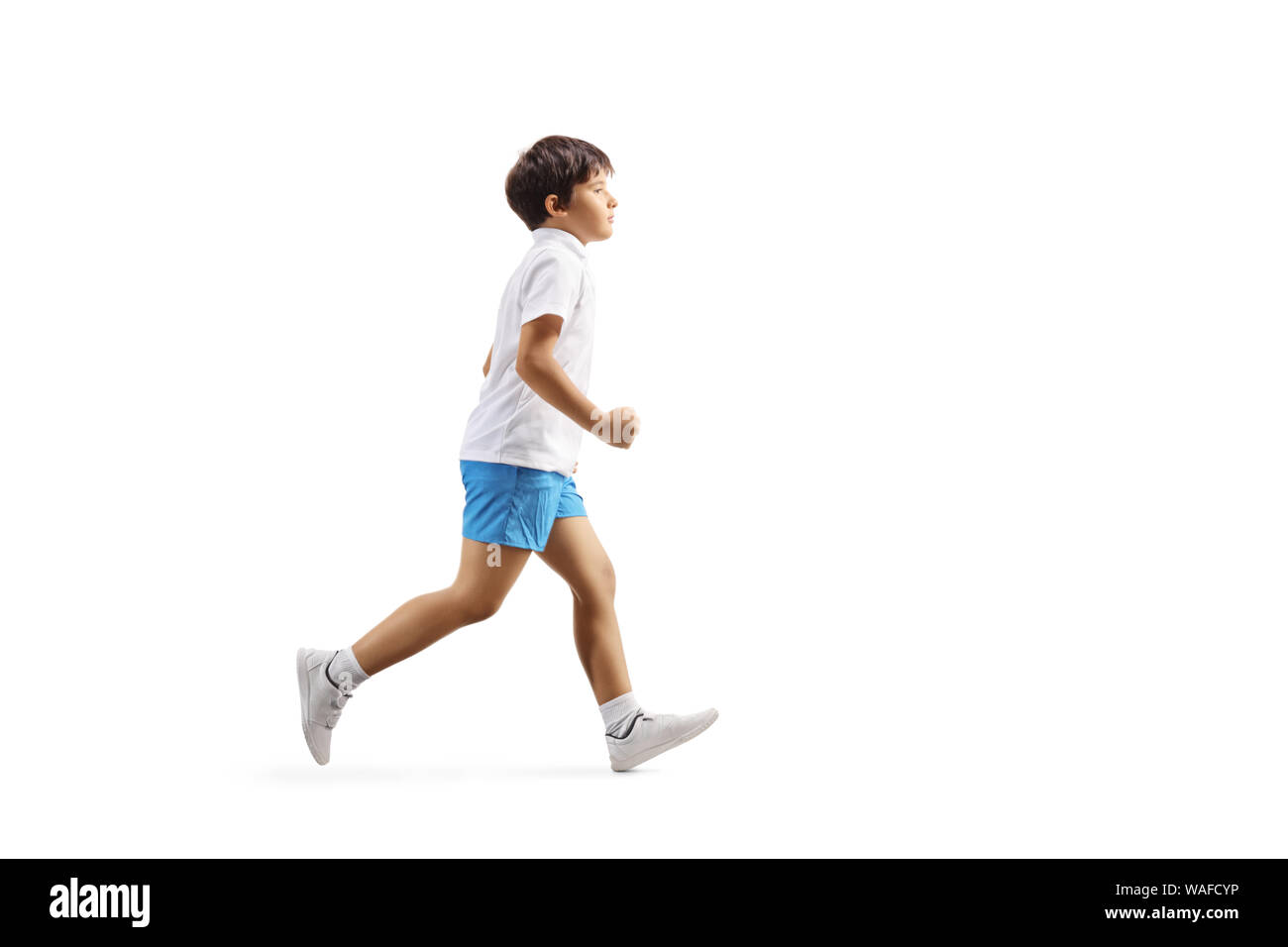 Full length profile shot of a little boy running isolated on white background Stock Photo