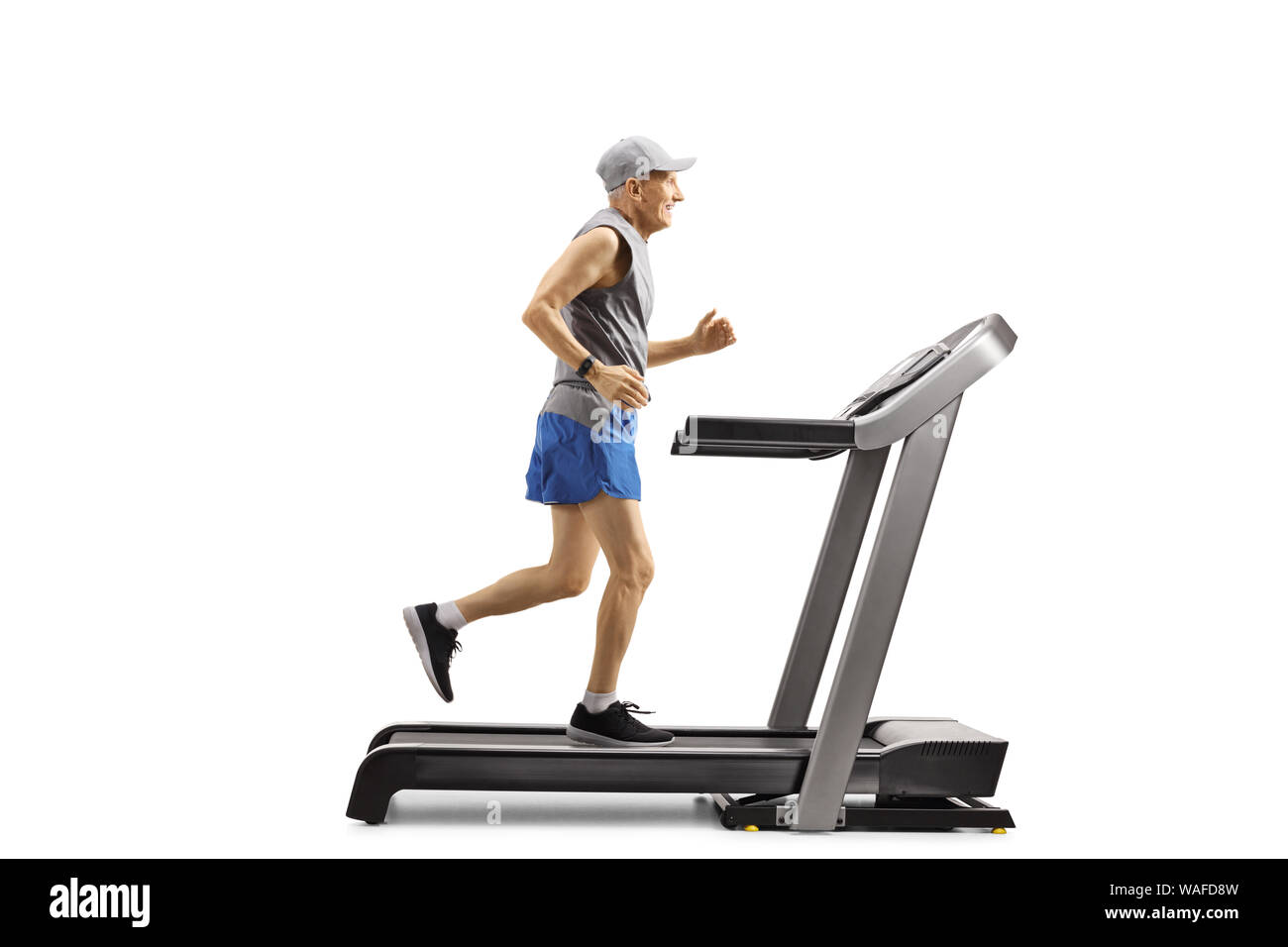 Full length profile shot of an elderly man running on a treadmill isolated on white background Stock Photo