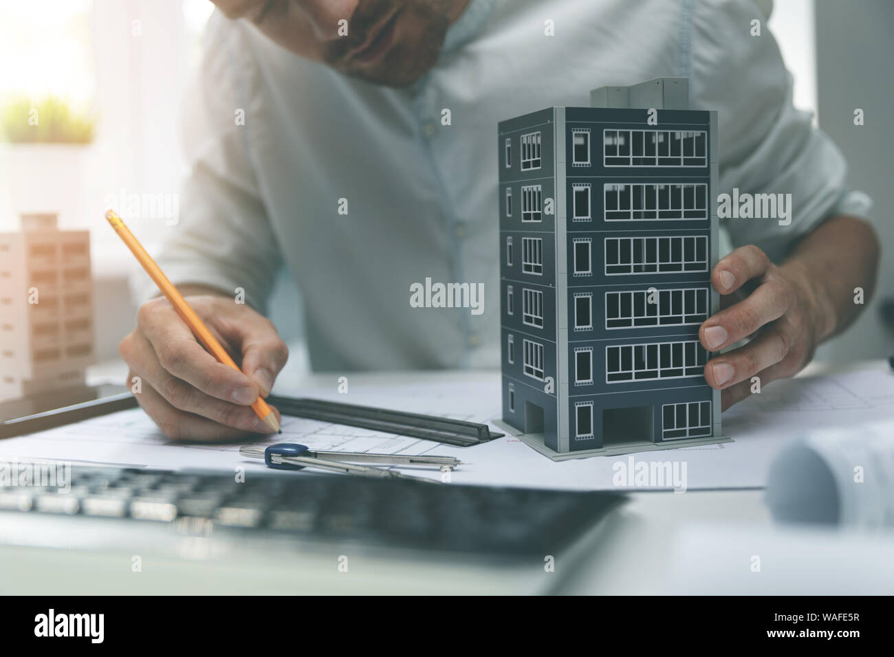 architect working with new apartment building scale model in office Stock Photo