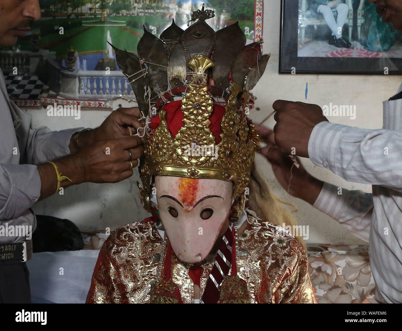 Lalitpur, Nepal. 20th Aug, 2019. A man is tied up the crown of deity Narsingh as he gets ready to participate in Narsingh Festival in Lalitpur, Nepal, Aug. 20, 2019. Narsingh Festival is one of the unique festivals celebrated in Lalitpur started by the Malla King of Patan, Siddhi Narsingh Malla, in 1631. The festival is celebrated annually in belief that it will bring peace to the soul of those who passed away, good health and prosperity. Credit: Sunil Sharma/Xinhua Stock Photo