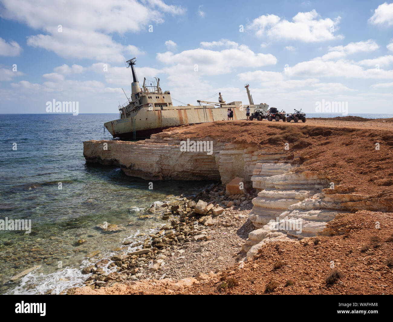 Paphos District, Cyprus - July 15, 2016: Tourists on quad bikes taking pictures near a shipwrecked EDRO III vessel Stock Photo