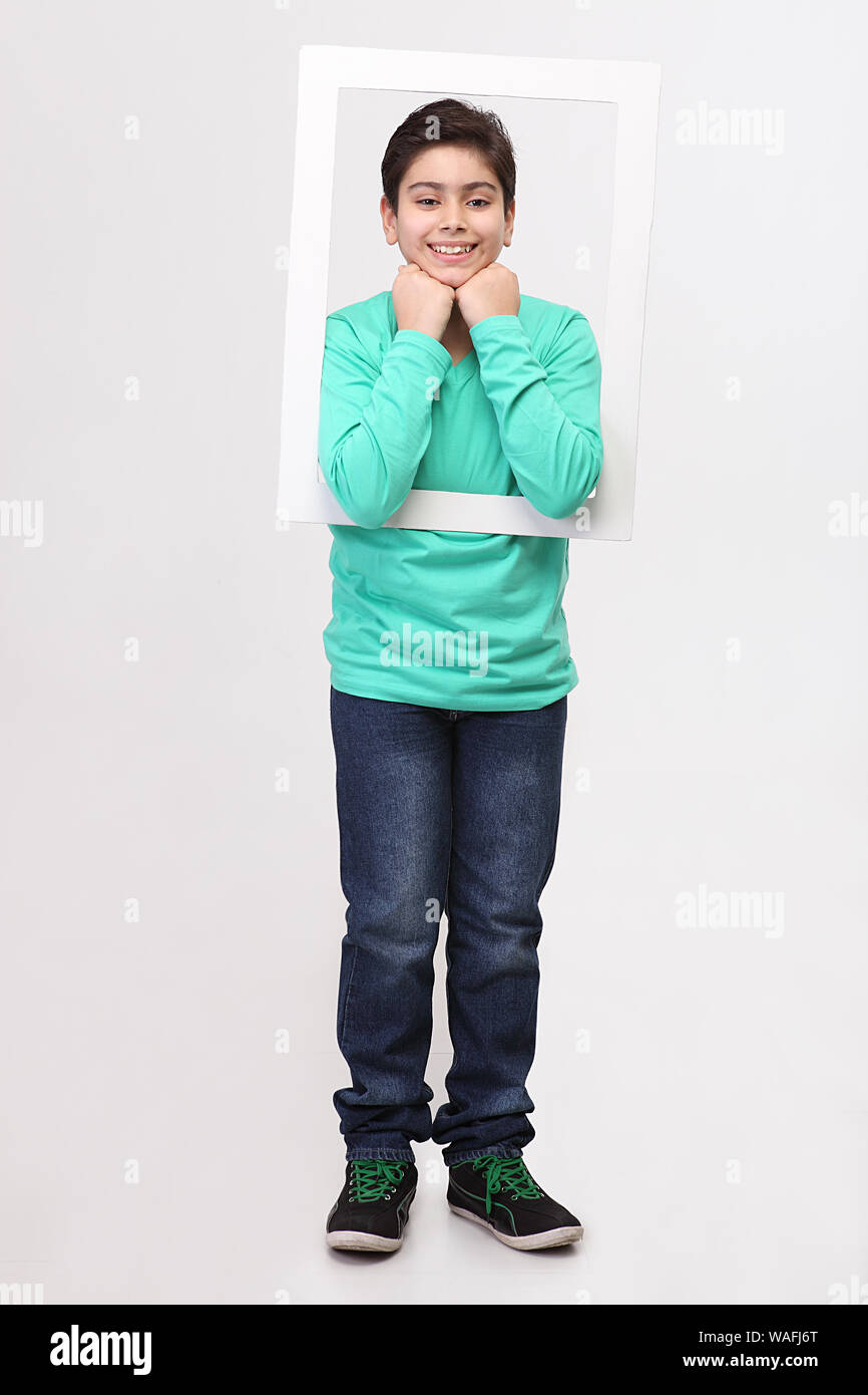 Boy holding a frame in front of her face Stock Photo