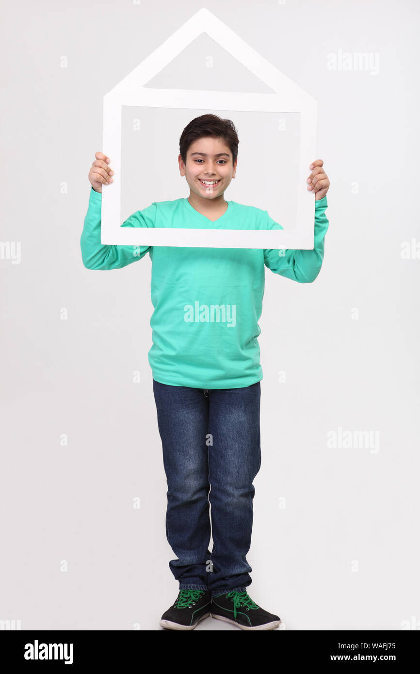 Boy holding a dream home shape frame Stock Photo